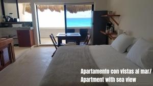 a bedroom with a bed and a desk with a view of the ocean at Casa Kay in Playa del Carmen