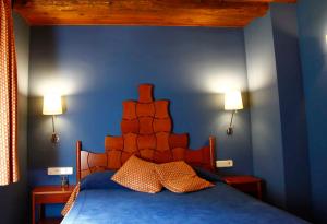 a bed in a room with a blue wall at Hotel Vall Ferrera in Areu