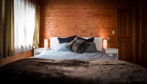 a bedroom with a bed and a wooden wall at Haus Yuki in Hakuba