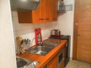 una pequeña cocina con fregadero y microondas en Depto Metro Santa Ana, en Santiago
