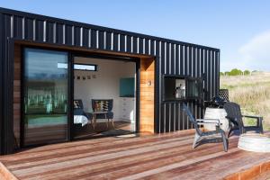 a building with sliding glass doors on a deck at Romantic Vineyard getaway in Waipara