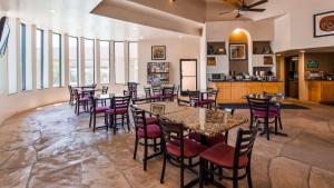 a dining room with tables and chairs and windows at Best Western Apache Junction Inn in Apache Junction