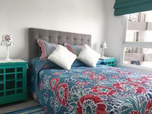 a bedroom with a bed with a blue and red blanket at Depto Metro Cal y Canto in Santiago