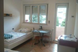 a bedroom with a bed and a desk and a table at eco Studio in Rijeka