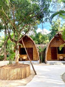 two huts with a tree in front of them at Cicada Lanta in Ko Lanta