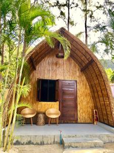 una piccola capanna con due sedie e una porta di Cicada Lanta a Ko Lanta
