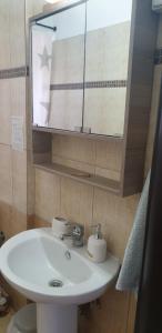 a bathroom with a white sink and a mirror at Maria's Luxury Apartment in Kassandria