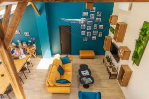 a living room with a yellow couch and blue walls at La Ressourçante in Puisieulx