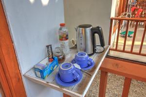 a shelf with two blue cups and a coffee pot on it at Saren Villa in Nusa Penida