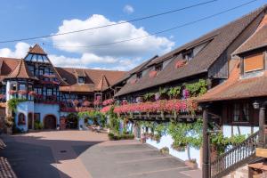 una calle en una ciudad medieval con flores en Hotel Kieffer, en Itterswiller