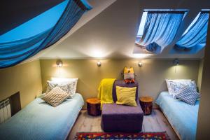 コストロマにあるАрт-отель Скворечникのベッド2台、椅子、窓が備わる客室です。