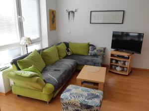 sala de estar con sofá verde y TV en Holiday Home Lipno Frymburk, en Frymburk