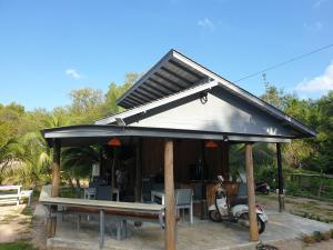 a house with a roof with a table and a scooter at Baan Suan Coconut Ko Yao Noi in Ko Yao Noi +18 photos