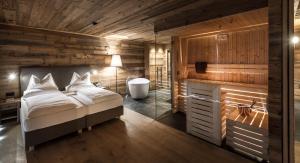 sypialnia z łóżkiem i wanną w pokoju w obiekcie Chalet Cogolara w mieście Colfosco