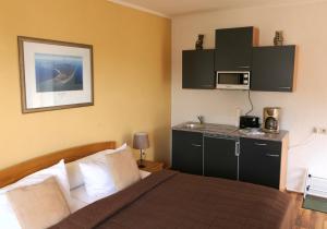 ein Hotelzimmer mit einem Bett und einer Mikrowelle in der Unterkunft Kapitänshaus in Strandnähe in Prerow in Prerow