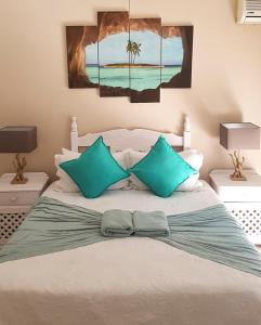 a bedroom with a bed with two blue pillows at Annas Bed and Breakfast in St Lucia