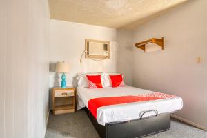 Habitación pequeña con cama con almohadas rojas en OYO Hotel Breckenridge TX Hubbard Creek Lake, en Breckenridge