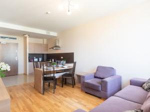 uma sala de estar com um sofá, uma mesa e cadeiras em VacationClub – Olympic Park Apartament A503 em Kolobrzeg