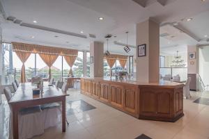 a large room with a bar with chairs and tables at RedDoorz Syariah near Ciledug Station in Cirebon
