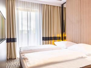 2 łóżka pojedyncze w sypialni z oknem w obiekcie VacationClub – Baltic Park Fort Apartament F.308 w Świnoujściu