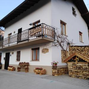 un gran edificio blanco con balcón y porche en Bed and Breakfast Ai Sassi, en Sovramonte