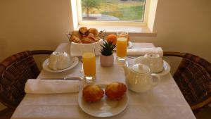 a table with a tea set with bread and orange juice at VILLA L'ESTAQUE in Armação de Pêra