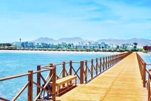 a row of wooden benches sitting on top of a pier at Steigenberger Alcazar in Sharm El Sheikh