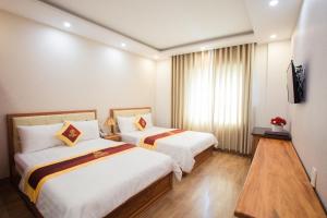 ein Hotelzimmer mit 2 Betten und einem TV in der Unterkunft Selima Hotel in Quy Nhon