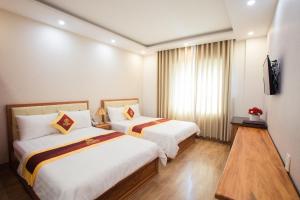 a hotel room with two beds and a television at Selima Hotel in Quy Nhon