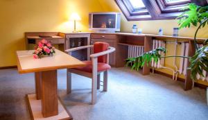 a room with a table and a tv and a chair at Ferienhotel Augustusburg in Augustusburg