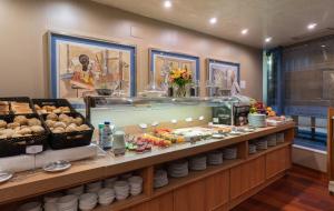 a buffet line with food on display in a restaurant at Hotel MS Maestranza Málaga in Málaga