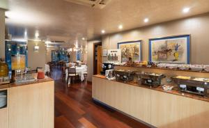 a restaurant with a counter and a restaurant with tables at Hotel MS Maestranza Málaga in Málaga