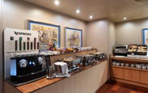 a coffee shop with a counter with a coffee maker at Hotel MS Maestranza Málaga in Málaga