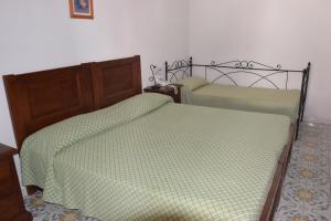 two beds with green comforters in a bedroom at Hotel Villaggio Stromboli - isola di Stromboli in Stromboli