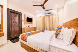 a bedroom with a bed and a ceiling fan at FabHotel Spark Inn Dwarakanagar in Vijayawāda