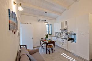 a kitchen and dining room with a couch and a table at La Villa 31 - Locazione Turistica in Rosignano Marittimo