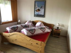 a bedroom with a wooden bed with pillows on it at Chalet Verbrunnenhaus Grindelwald in Grindelwald
