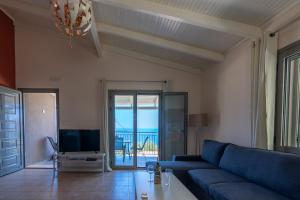 a living room with a blue couch and a tv at Villa Athina in Angón