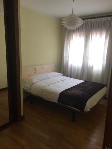 uma cama num quarto com uma janela em CONOCE CANGAS DE ONIS em Cangas de Onís