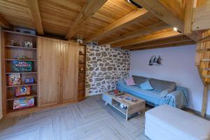 uma sala de estar com um sofá azul e tectos em madeira em Guarda il porto em Hydra