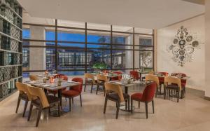 un restaurante con mesas y sillas y una gran ventana en Dusit Thani Residence Davao en Davao