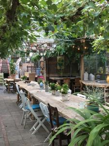a long wooden table with chairs and potted plants at 't Keetje in Groesbeek