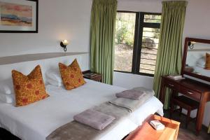 a bedroom with a large white bed with a window at Sungubala Eco Camp in Bergville