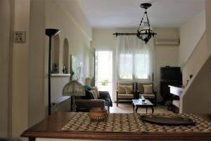 ein Wohnzimmer mit Sofa und Tisch in der Unterkunft Traditional House in Peraia