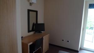 CapistrelloにあるHotel de Meisのテレビと鏡が付いた机のある部屋