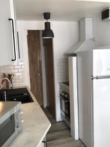 eine Küche mit einem weißen Kühlschrank und einer Mikrowelle in der Unterkunft Gite Bel Air La Mongie in La Mongie
