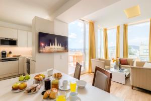 eine Küche und ein Wohnzimmer mit einem Tisch mit Essen drauf in der Unterkunft Vienna Grand Apartments DANUBE in Wien