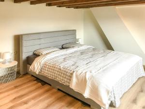 een slaapkamer met een groot bed en een houten vloer bij Het Boomkwekerijhuis in Zonnebeke