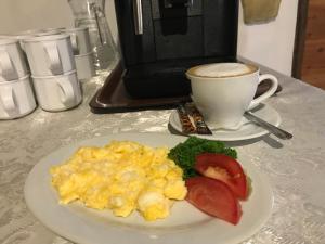 un plato de huevos revueltos y una taza de café en Karczma Pod Topolami, en Ratowo Piotrowo