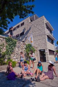 un gruppo di persone seduti di fronte a un edificio di HI Hostel Dubrovnik a Dubrovnik